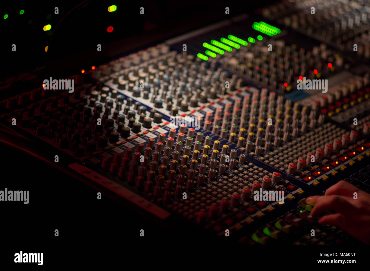 Table de mixage avec le sait et voyant vert s'allume dans un lieu sombre avec une profondeur de champ étroit Banque D'Images