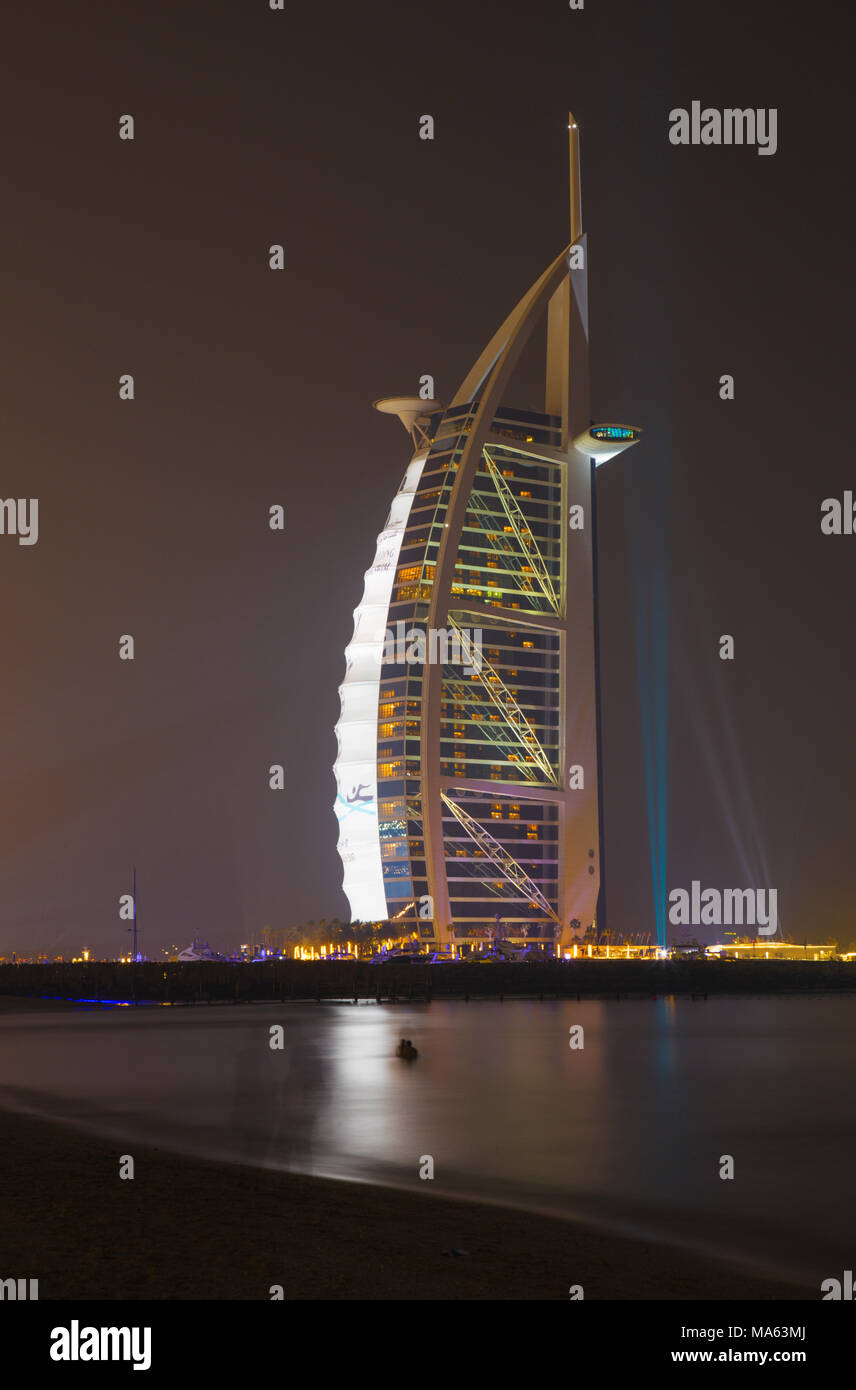 Dubaï, Émirats arabes unis - DUBAÏ, ÉMIRATS ARABES UNIS, LE 30 MARS 2017 : le Burj Al Arab en soirée et Marina towers de l'arrière-plan. Banque D'Images