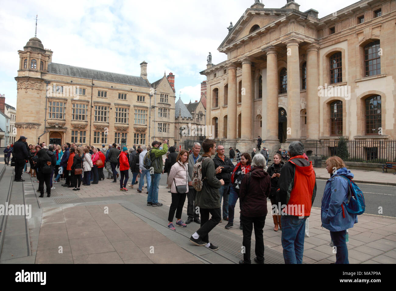 Des groupes de touristes d'être abordées par les guides en face de l'immeuble et le Clarendon Oxford Martin School, Oxford Banque D'Images