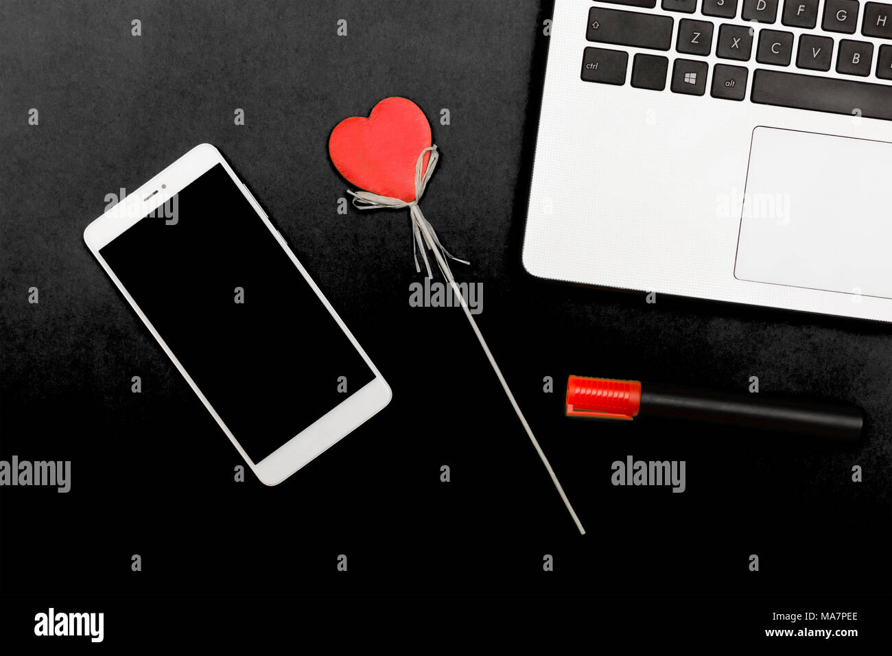 Symbole coeur d'un ordinateur portable smartphone. Un cœur décoratif sur un fond jaune avec smart gadgets. Banque D'Images