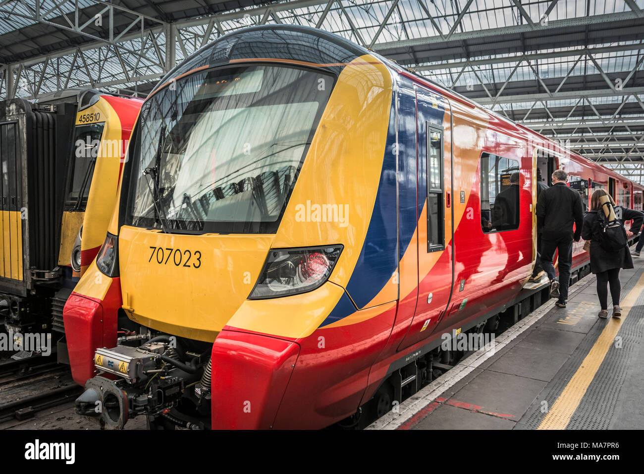 Les passagers se précipiter pour un départ de South Western Railway, Desiro City Class locomotive 707, construit par Siemens. Banque D'Images