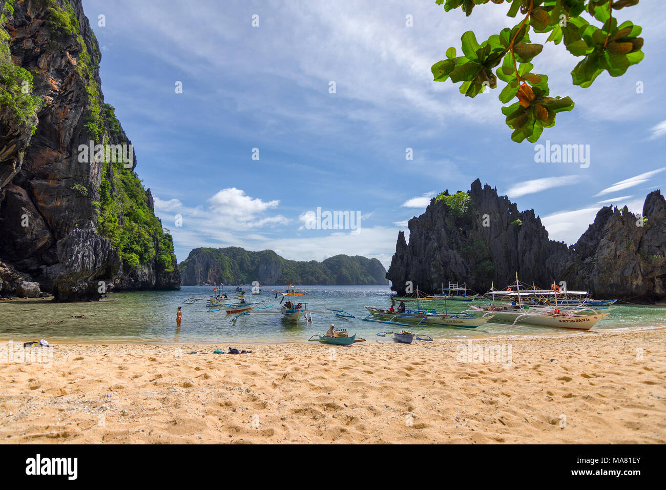 L'île touristique Philippines bateaux espérant un jour ensoleillé débarqués sur une plage de sable blanc avec un fond de bateaux en mer entre les îles tropicales Banque D'Images