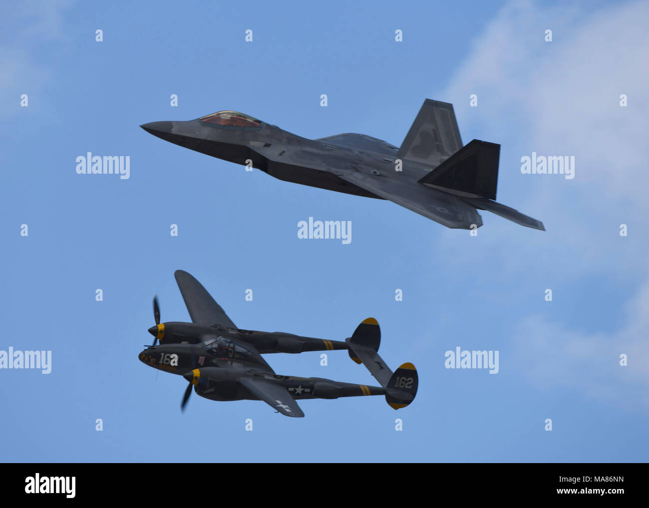 Un U.S. Air Force F-22 Raptor vole à côté d'un P-38 Lightning pendant un vol du patrimoine au Los Angeles County Air Show à Lancaster, en Californie, le 24 mars 2018. Vol du patrimoine éduque ceux sur l'avion de chasse de la Seconde Guerre mondiale, la Corée et le Vietnam tout en l'honneur des anciens combattants qui ont participé. (U.S. Photo de l'Armée de l'air par la Haute Airman Kaylee Dubois) Banque D'Images