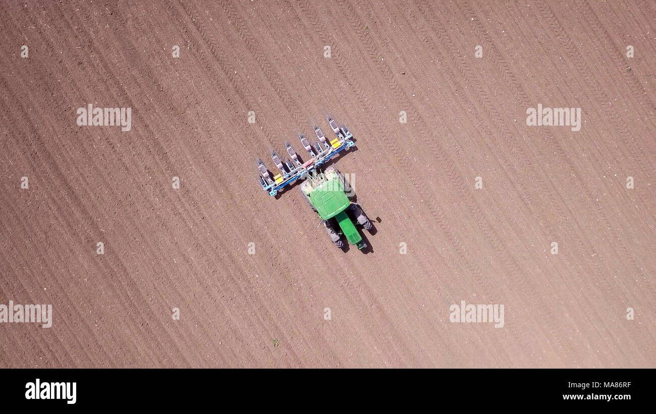 Tracteur vert labourer la terre sèche - Droit aérien Banque D'Images