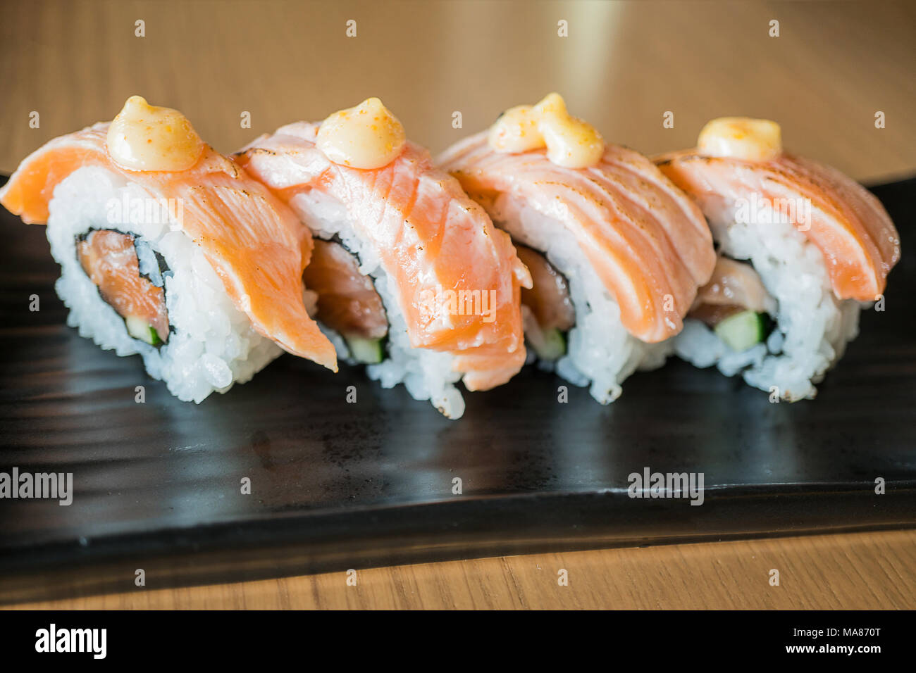 Pavé de saumon sushi roll, nourriture japonaise sur style plat de céramique noire Banque D'Images