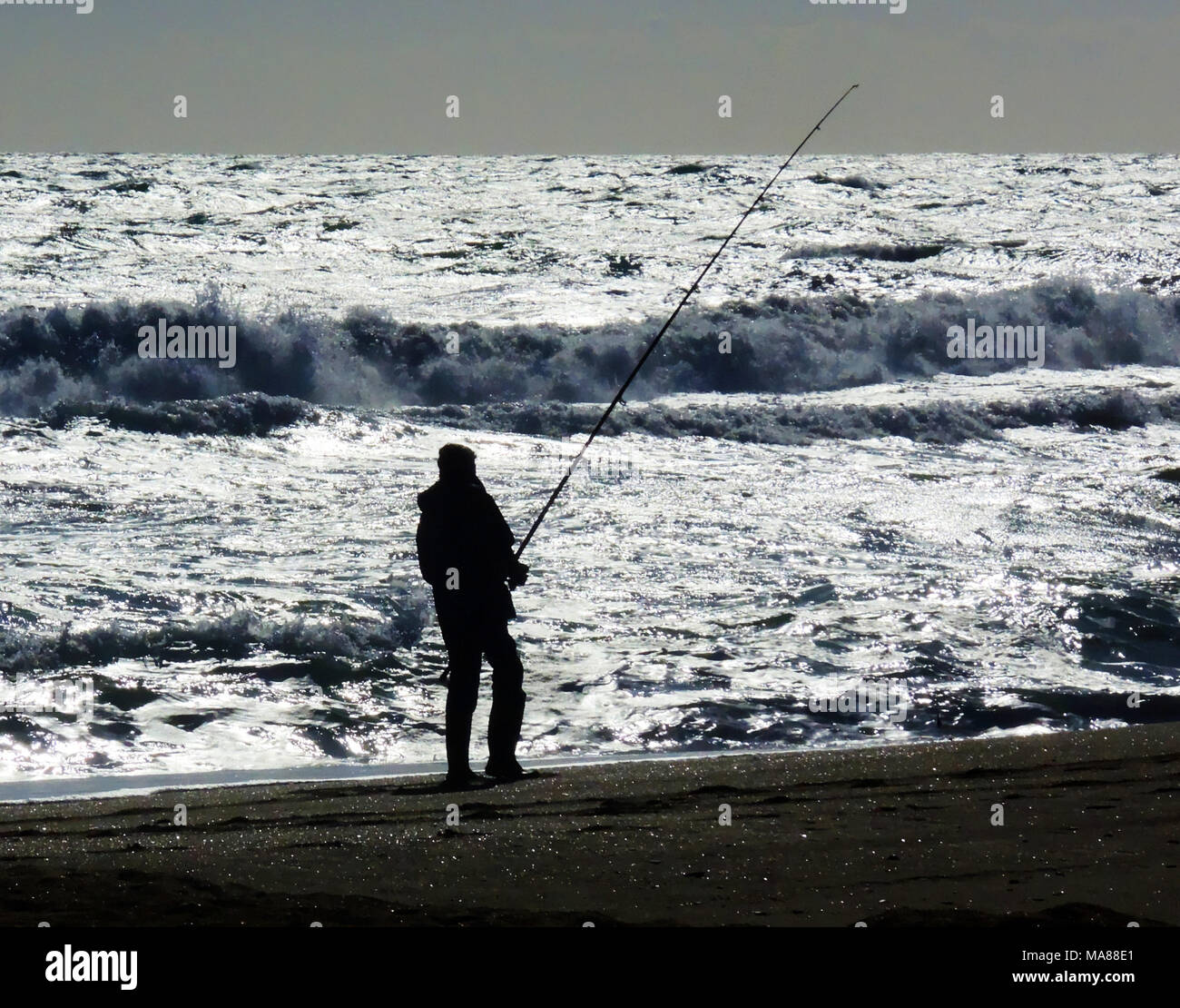 Un pêcheur silhouette sur l'océan. Banque D'Images