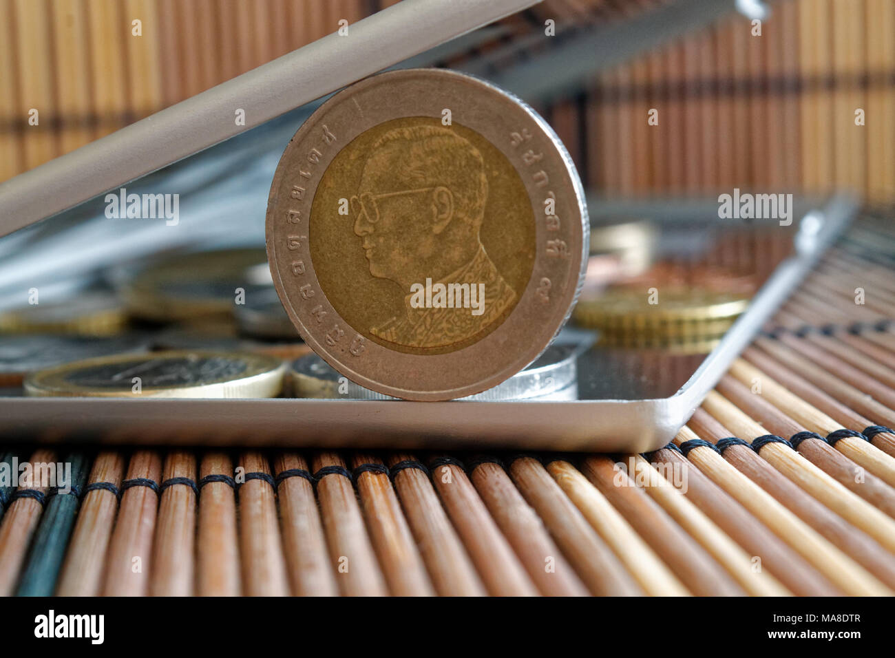 Pile de pièces en thaï reflètent miroir wallet se trouve sur l'arrière-plan en bois table en bambou dénomination est de 10 baht - verso Banque D'Images