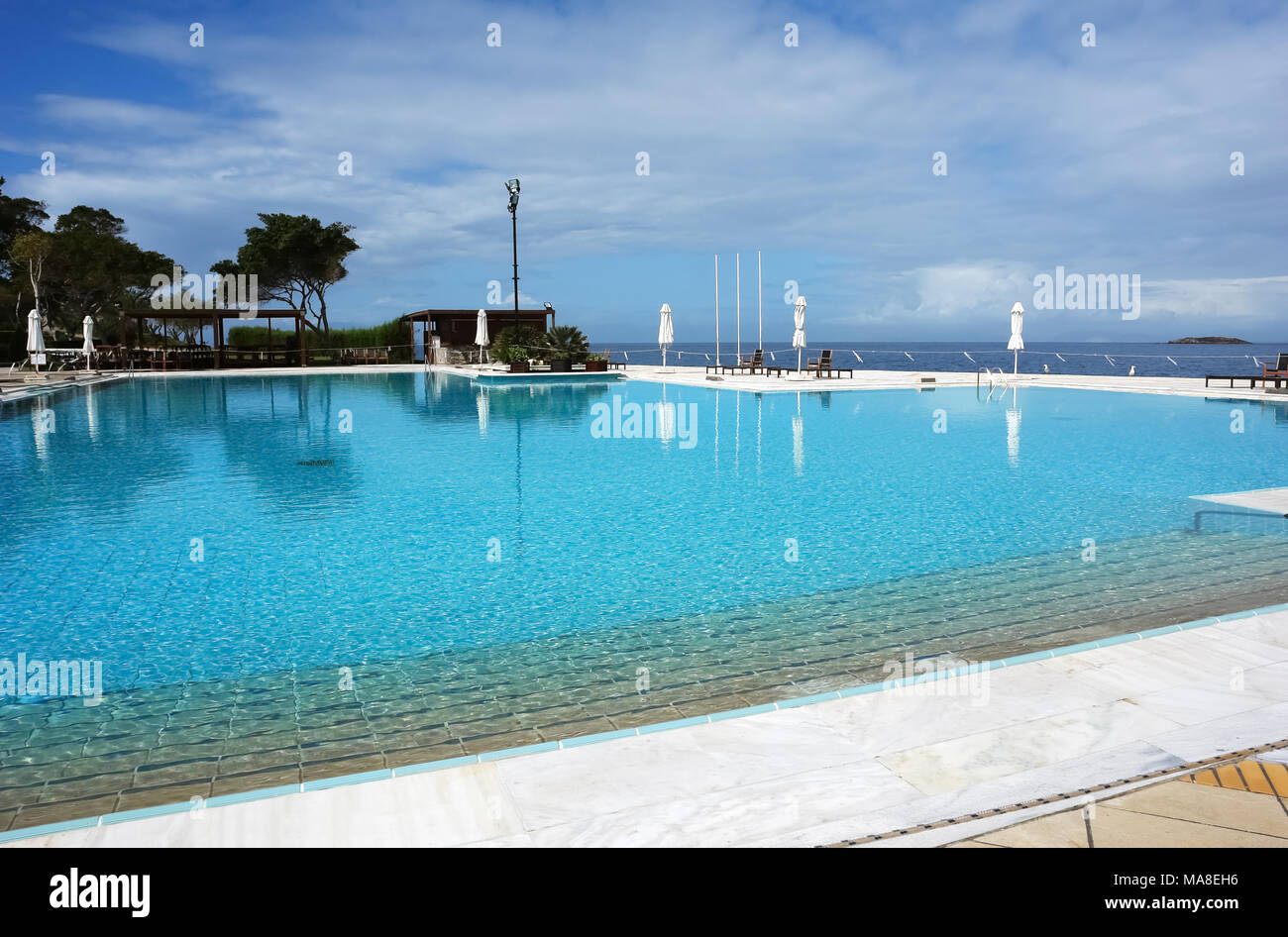 Vouliagmeni, Grèce - 28 mars 2015 : vue sur la grande piscine et la mer bleue en hôtel de luxe moderne sur la côte égéenne. Banque D'Images