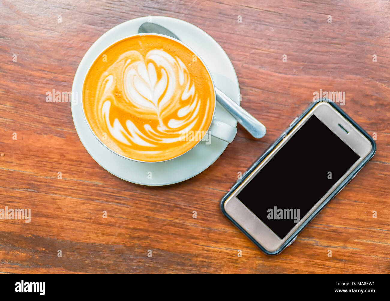 Tasse de café Latte art avec smart phone. Banque D'Images