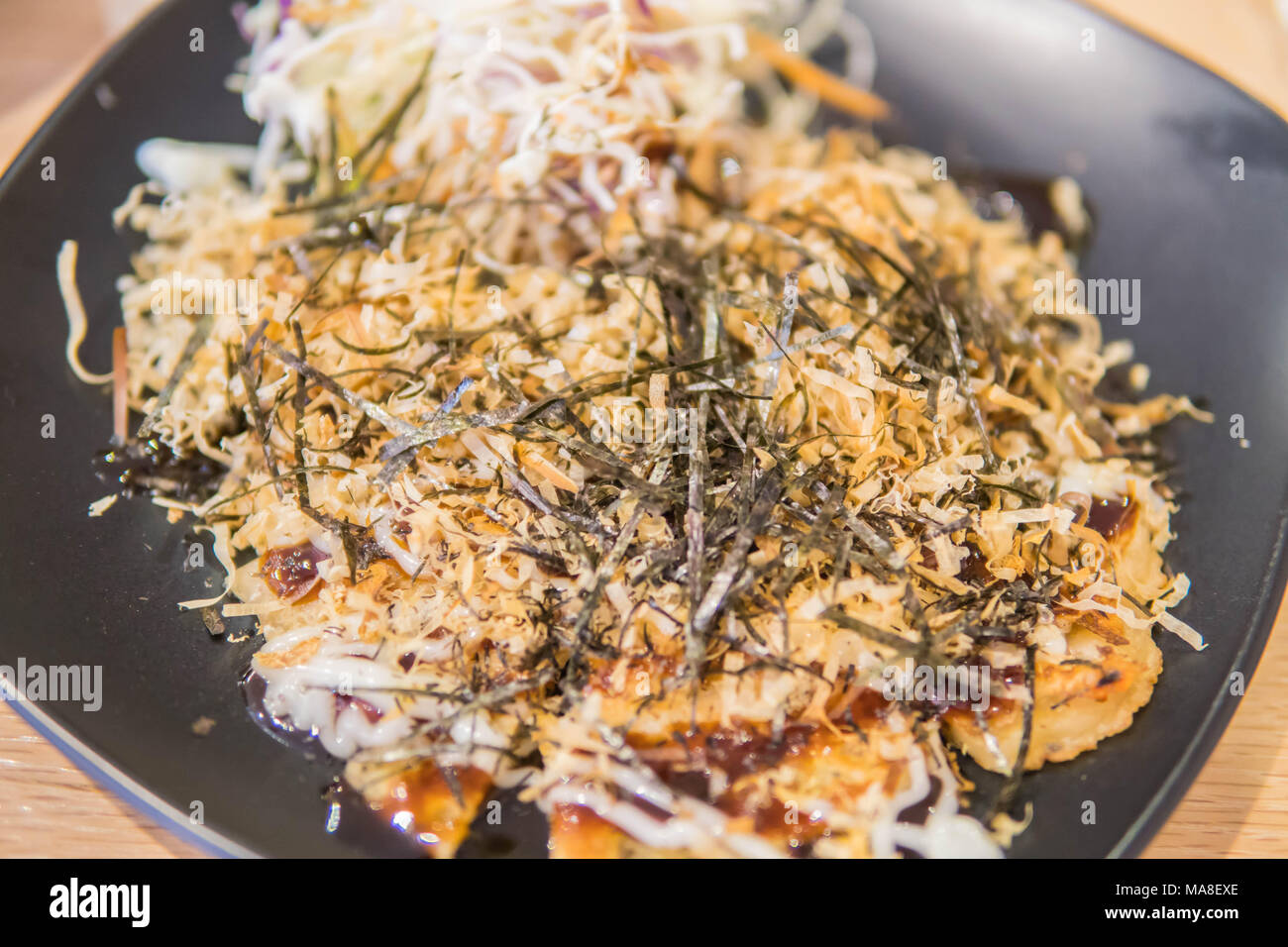 Style japonais KANSAI Okonomiyaki ,salé crêpe ou connu sous le nom de pizza japonaise ce plat peut facile à faire à la maison. Banque D'Images