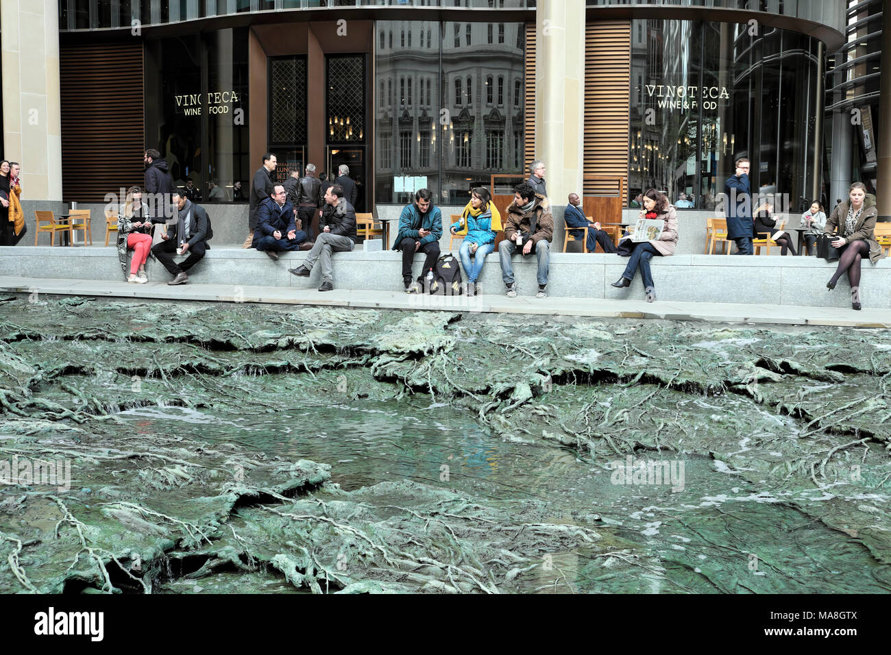 Des gens assis par 'oublié' d'eau sculpture de l'artiste Cristina Iglesias au Siège de Bloomberg dans City of London UK KATHY DEWITT Banque D'Images