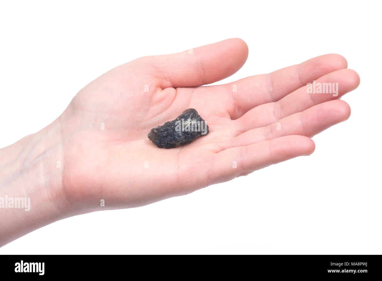 Young woman holding moldavite - forme d'tektite trouvés le long des rives de la rivière Moldau en République tchèque, isolé sur fond blanc Banque D'Images