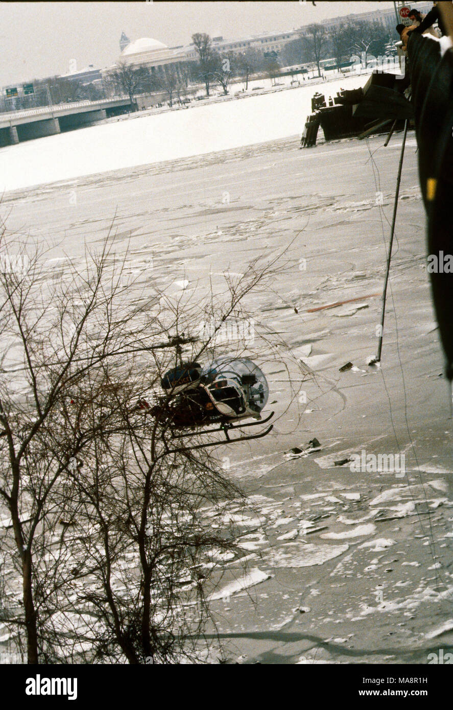 Washington, DC., USA, 14 janvier 1982 Le 13 janvier 1982, Vol 90 Air Florida s'écrase sur Washington, DC's 14th Street Bridge et est tombé dans la rivière Potomac peu après le décollage. Un total de 70 passagers, 4 membres d'équipage et 4 automobilistes sur le pont ont été tués. L'accident du Boeing 737-200 était dû à un système anti-givrage étant laissé. Un hélicoptère de la Police DC plane au-dessus de la zone de la rivière Potomac, juste au nord de la 14th Street Bridge span qu'Air Florida a frappé la veille puis plonger dans les eaux glacées pour preuve. Credit : Mark Reinstein/MediaPunch Banque D'Images