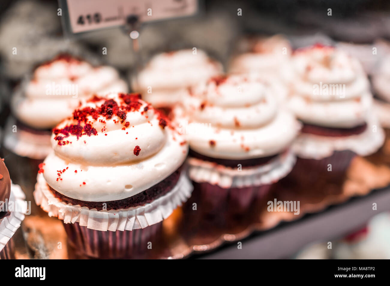 Gros plan macro de Red Velvet cupcakes à l'écran en boulangerie dans les écrans de papier à muffin avec fromage à la crème glaçage glaçage blanc Banque D'Images