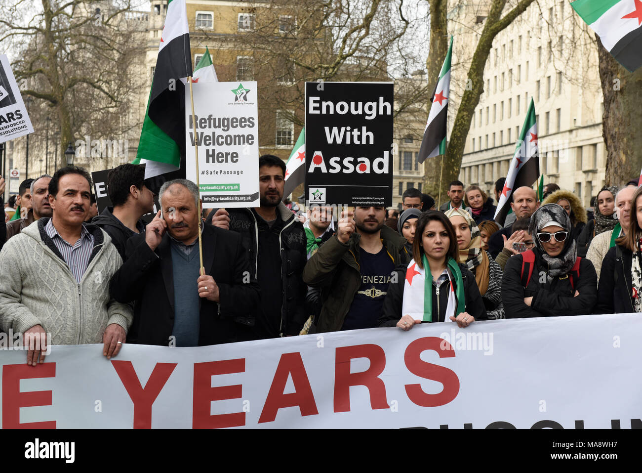 Les manifestants syriens tiennent des pancartes tout en manifestant contre le régime Assad en dehors de la Downing Street, à Londres, Royaume-Uni. Banque D'Images