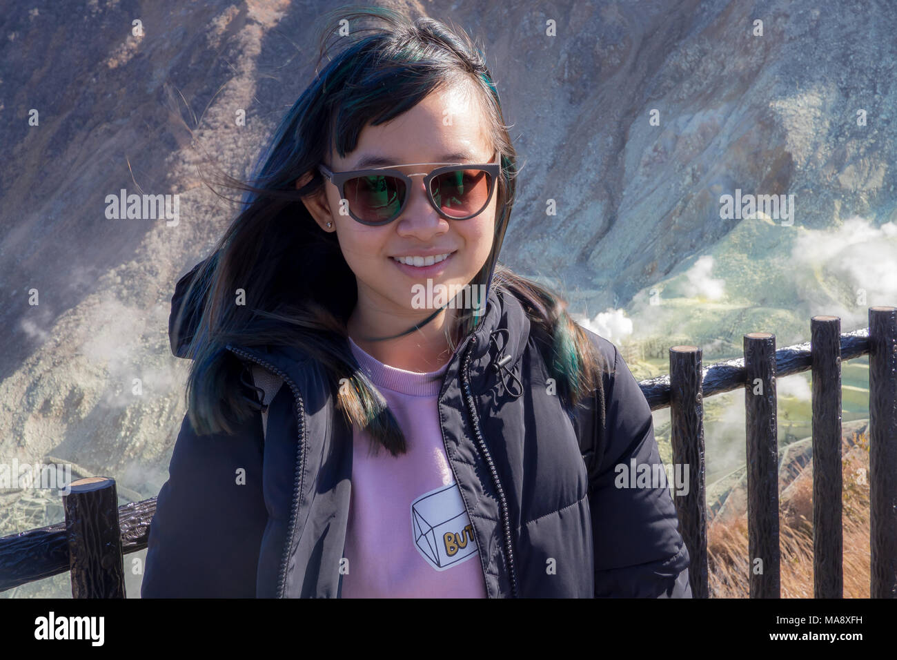 Voyageuses avec des lunettes qui pose en face du Mont Hakone's volcan actif Banque D'Images