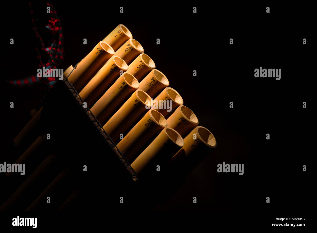 Détail d'une flûte de pan sur un fond noir. Banque D'Images