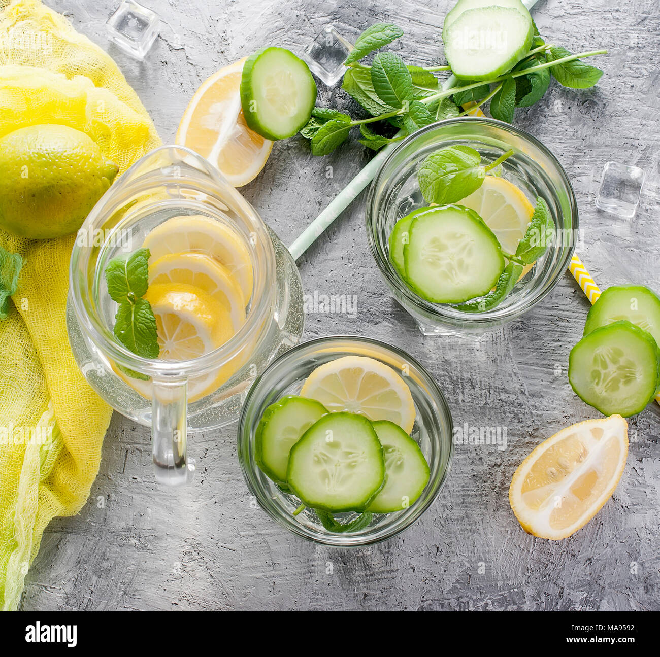 Les agrumes et les herbes de l'eau infusée sassi pour désintoxication, la saine alimentation dans les verres et verseuse sur sur fond sombre Banque D'Images