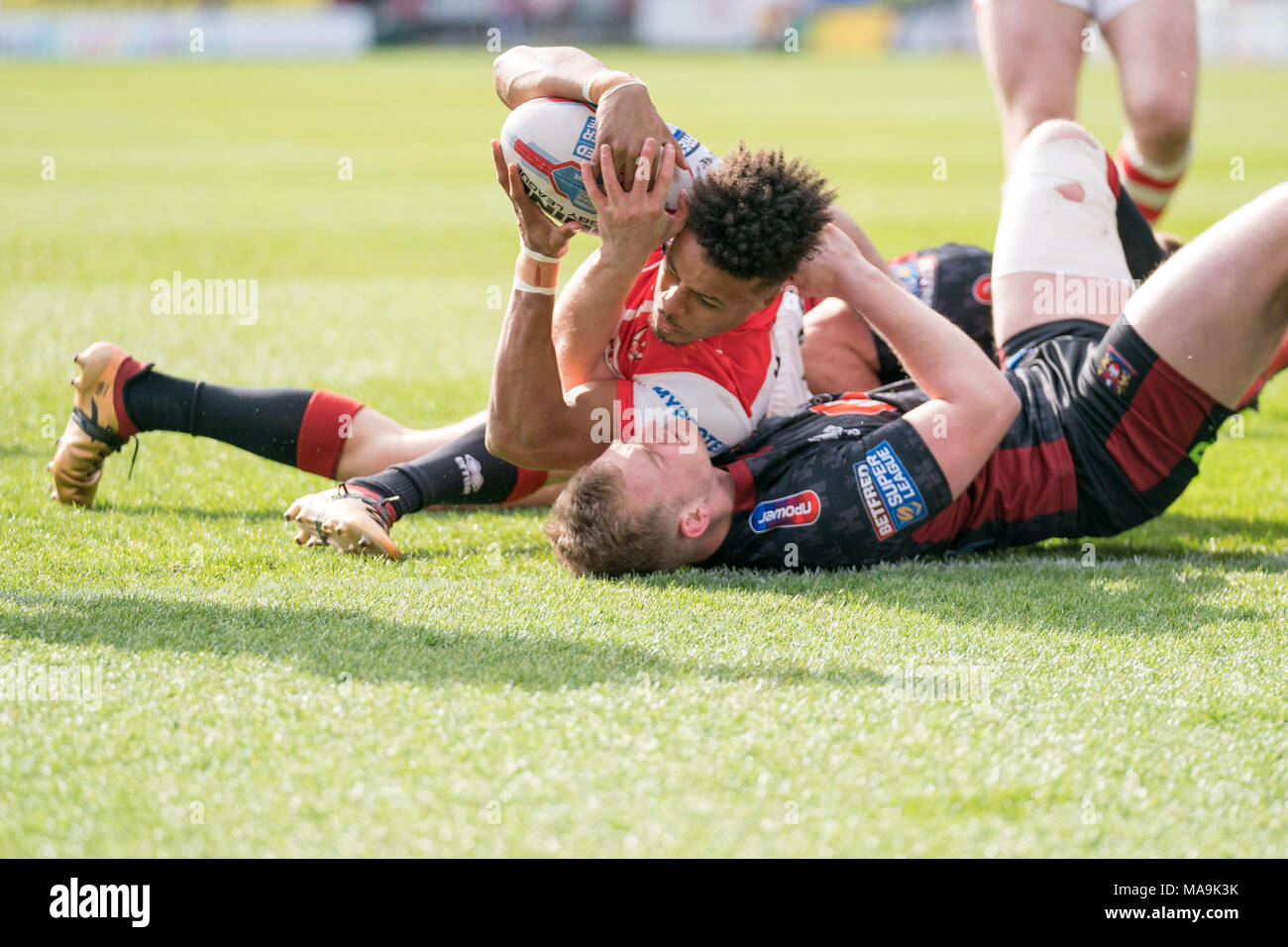 Le Merseyside (Royaume-Uni). 30 mars, 2018. Saint Helens's Regan Grace est abordé par Wigan Warriors's Josh Woods 30 MARS 2018 , totalement méchant Stadium , Merseyside, Angleterre ; Betfred Super League rugby, ronde 8, St Helens v Wigan Warriors ; Crédit : Nouvelles Images/Alamy Live News Banque D'Images