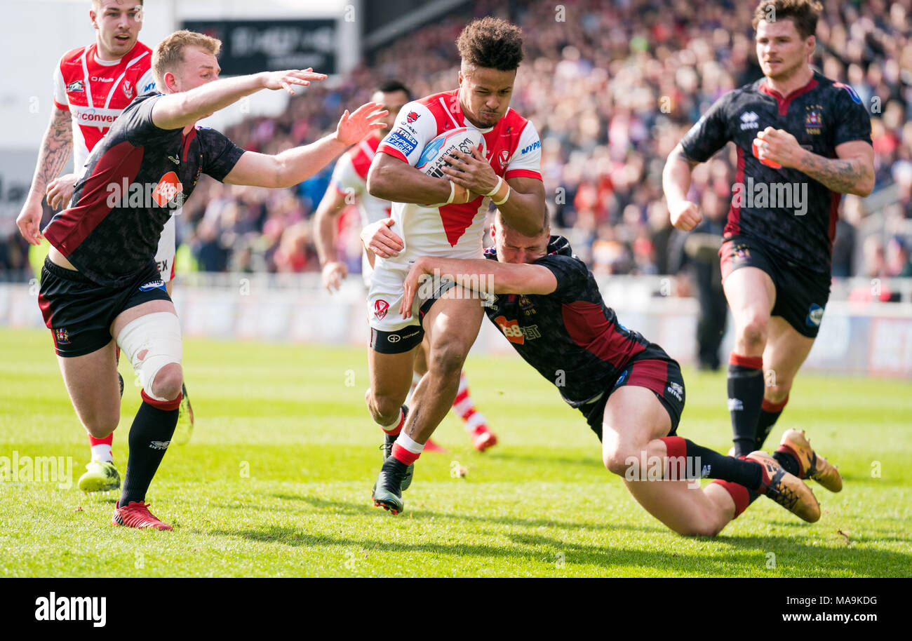 Saint Helens's Regan Grace est abordé par Wigan Warriors's Josh Woods 30 MARS 2018 , totalement méchant Stadium , Merseyside, Angleterre ; Betfred Super League rugby, ronde 8, St Helens v Wigan Warriors. Banque D'Images