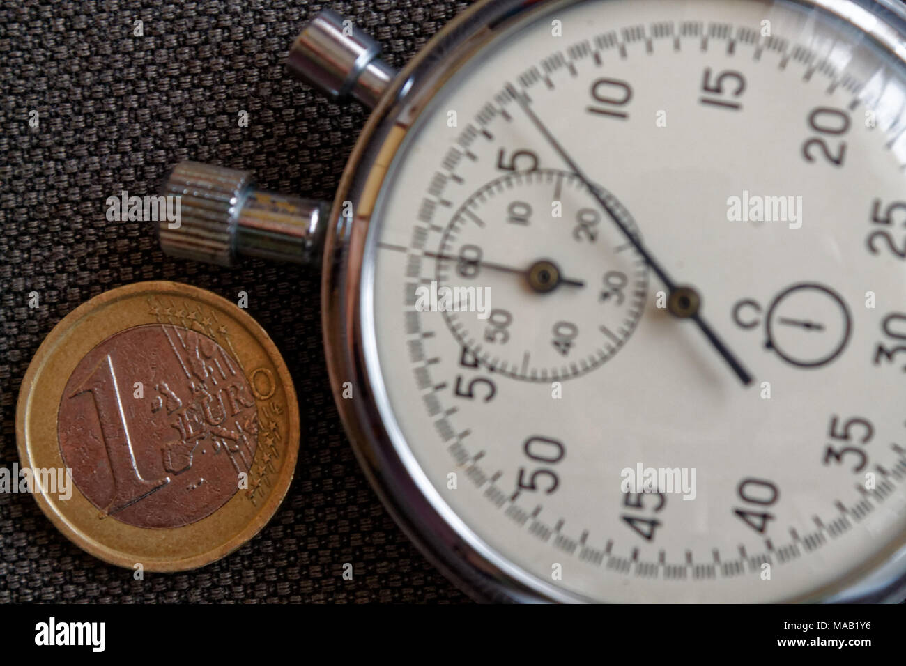 Pièce en euros avec une valeur nominale d'un euro et le chronomètre sur toile Denim marron - business background Banque D'Images