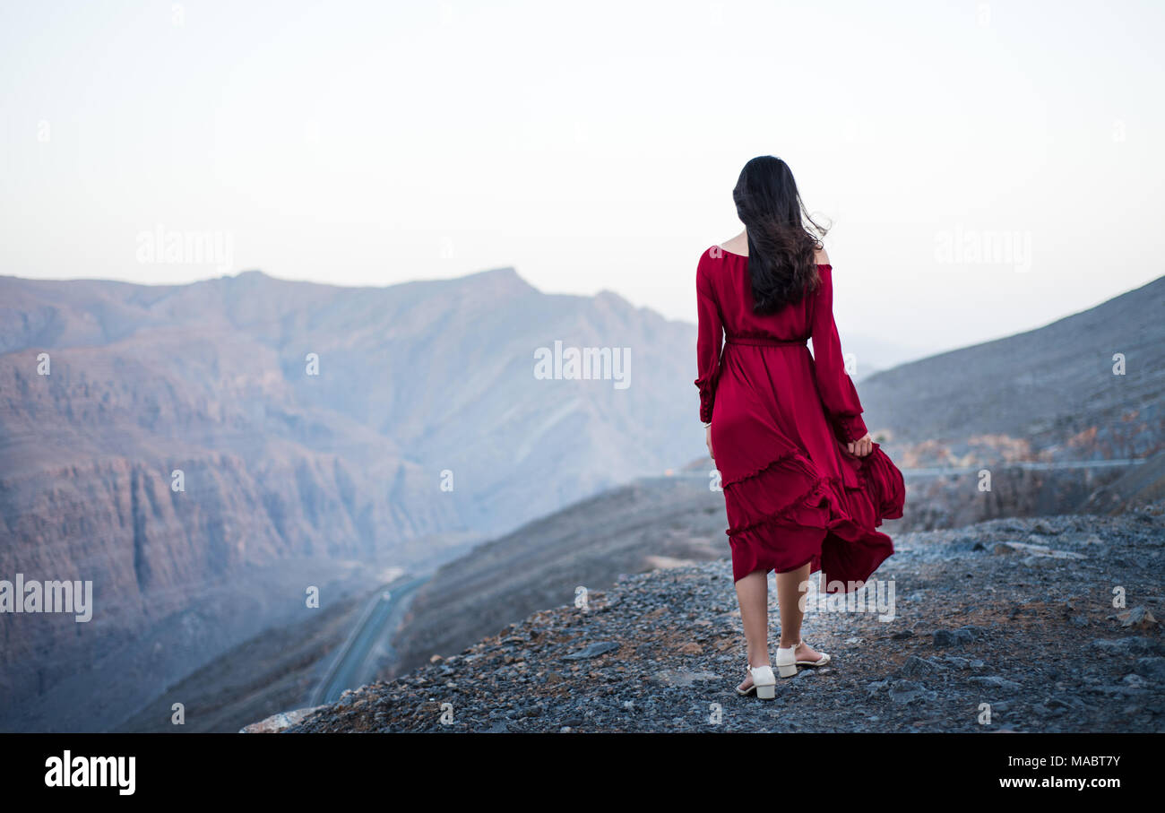 Fille à la mode sur un sommet de montagne désert wearing red dress Banque D'Images