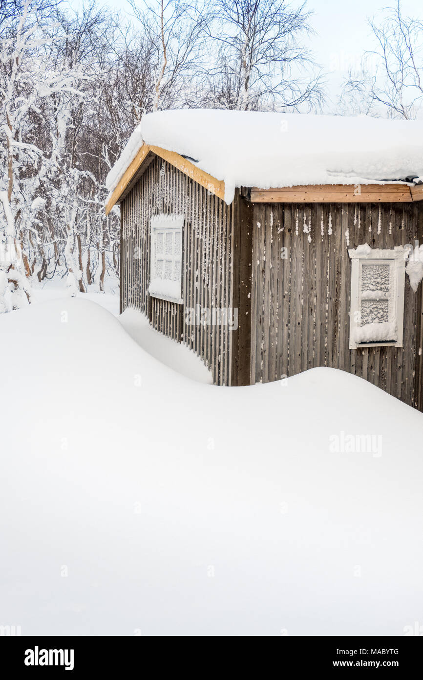 Chalet couvert de neige dans un village sami en Laponie suédoise Banque D'Images