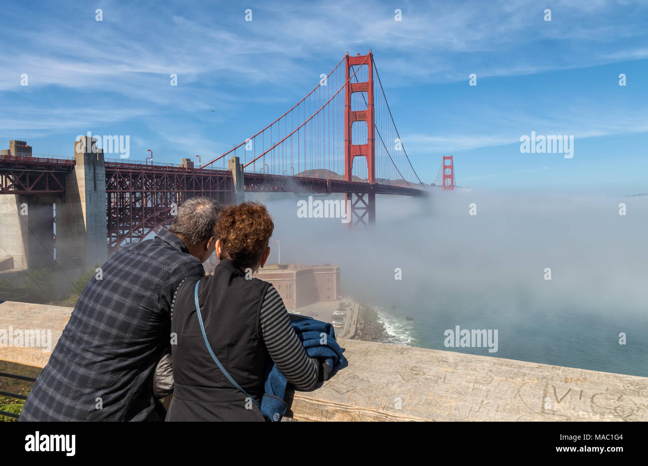 Un couple a été en regardant le pont Golden Gate, avec brouillard inférieur en dessous, San Francisco, California, United States. Banque D'Images