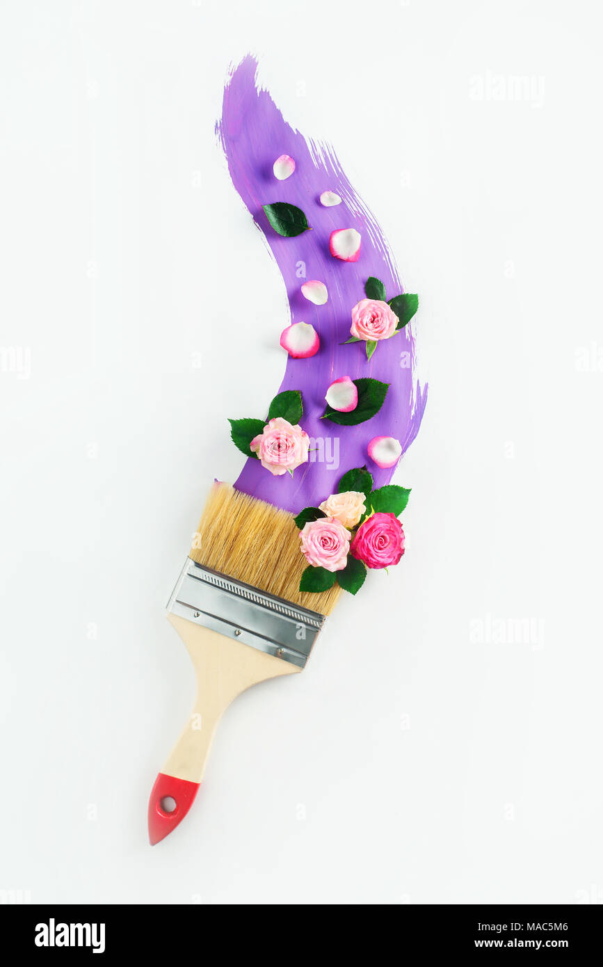 Peinture violet avec un pinceau et de l'arrangement de fleurs sur fond blanc. Printemps peinture concept créatif avec l'exemplaire de l'espace. Banque D'Images