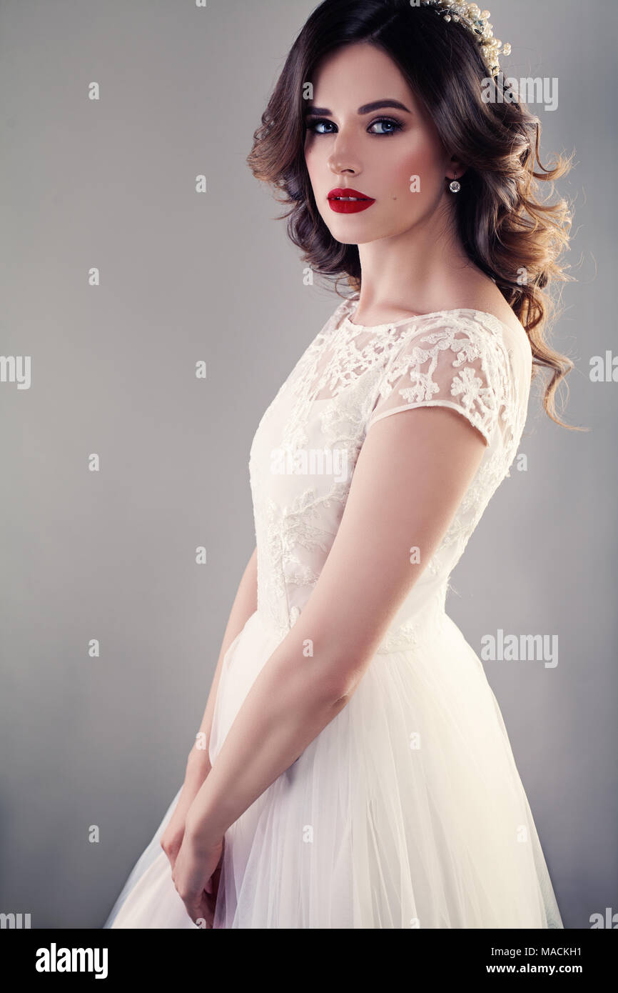 Belle Mariée robe de mariage en blanc, jolie fille fiancée avec des cheveux bouclés et un miroir sur l'arrière-plan Banque D'Images