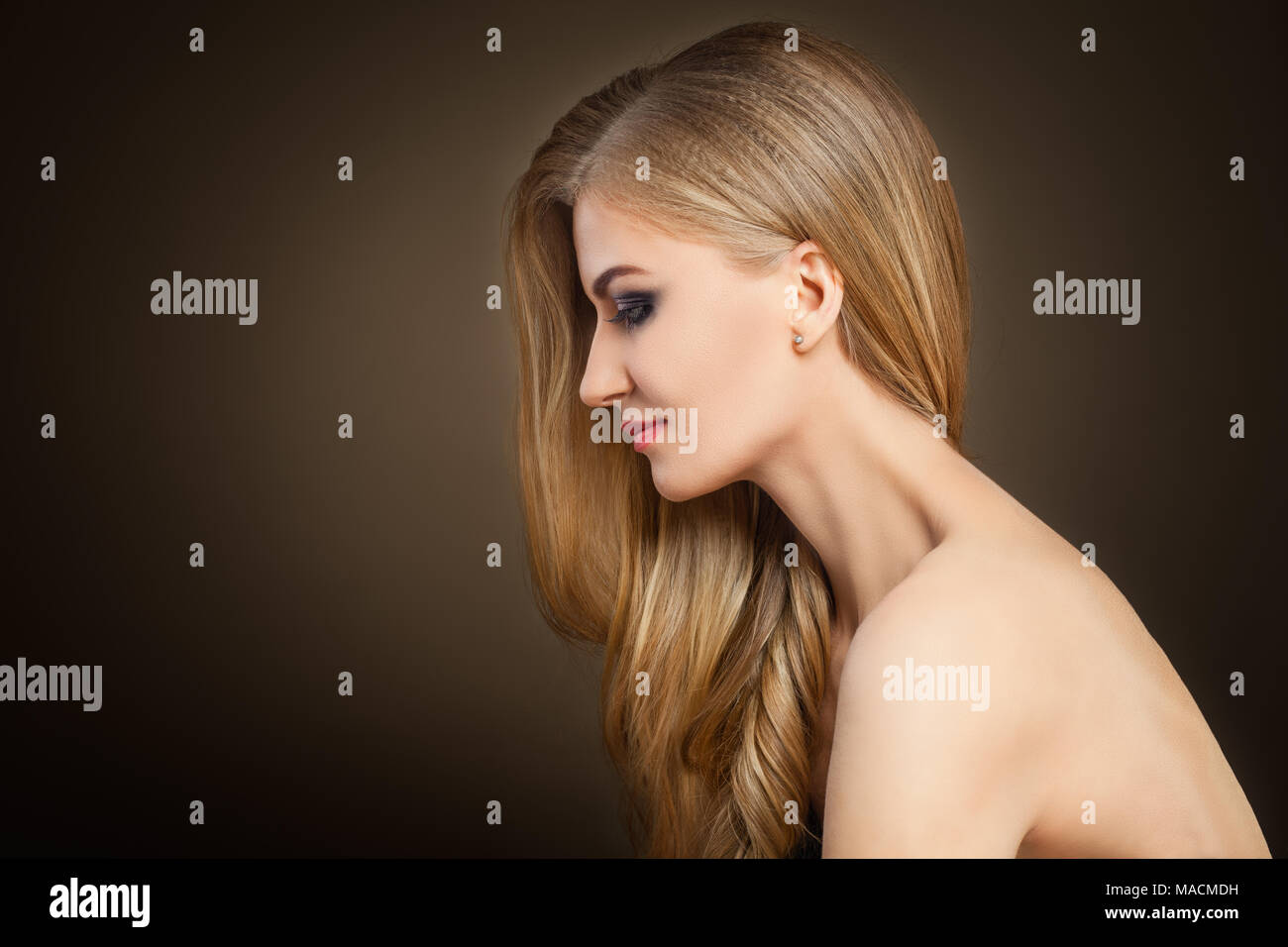 Femme blonde en bonne santé avec de longs cheveux sur fond sombre with Copy space Banque D'Images