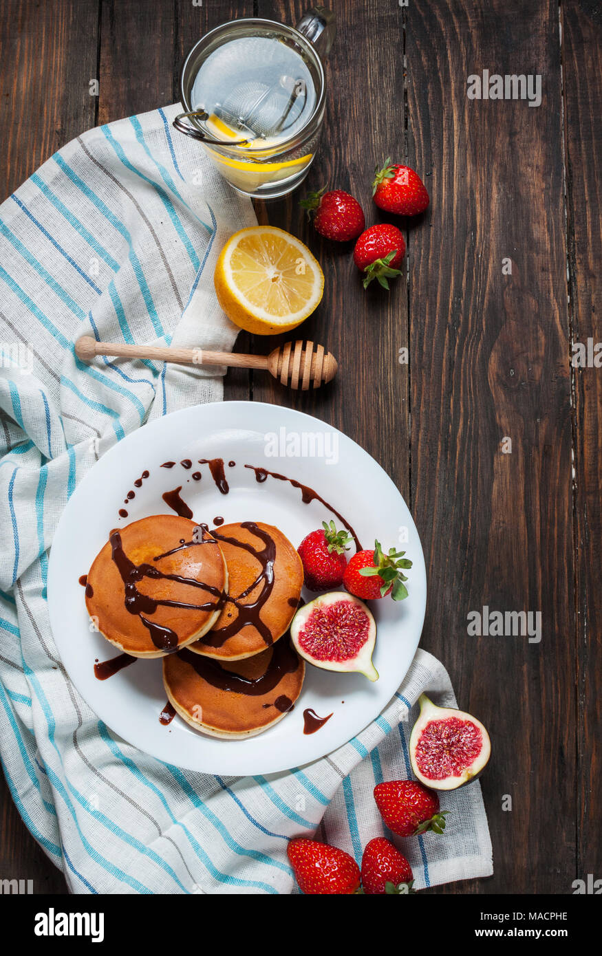 Tasse de thé et des pancakes aux figues, fraises sur plaque blanche libre. Banque D'Images
