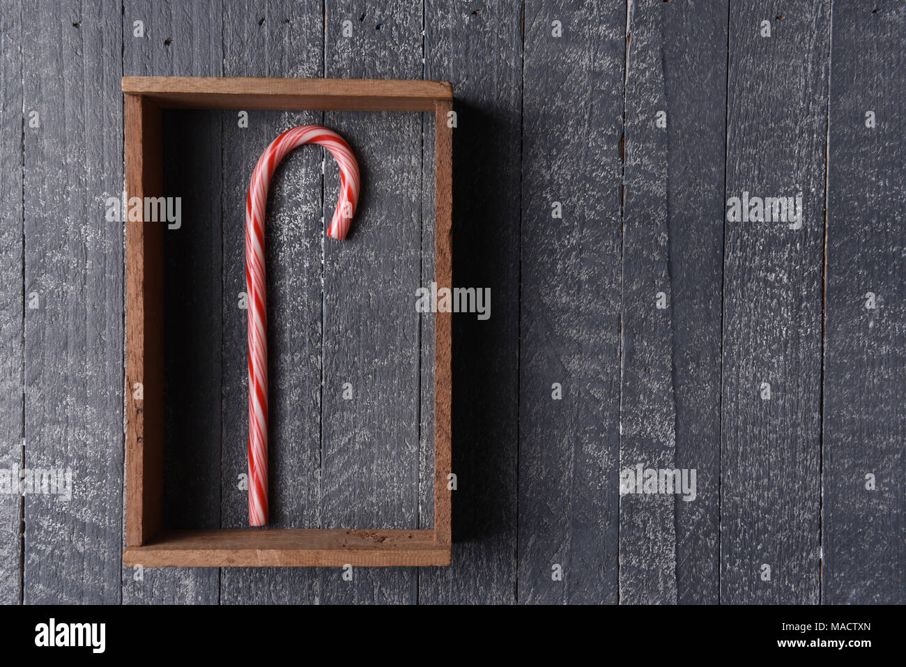 Une canne dans une ossature de bois sur mur rustique gris. Banque D'Images