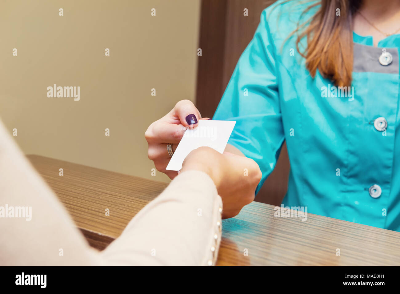 Close up of réceptionniste donner carte de visite avec vide vide pour female patient in clinique médicale. Focus sélectif, de l'espace pour le texte. Banque D'Images