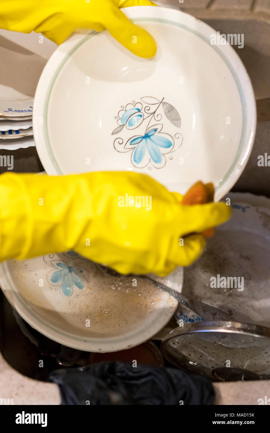 Woman's hands dans les gants laver la plaque. libre Banque D'Images