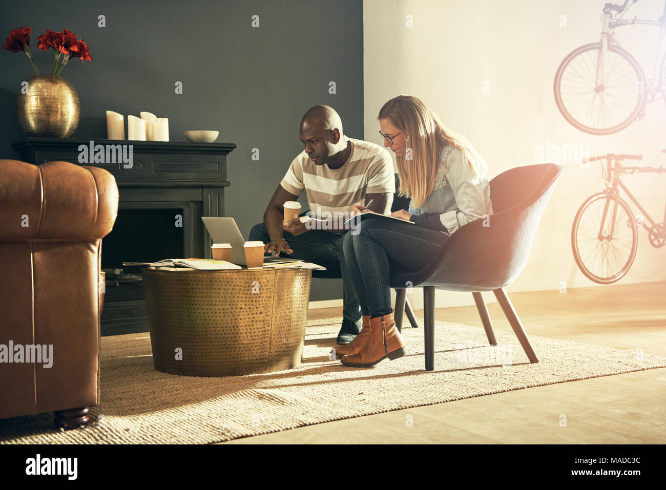 Deux jeunes architectes et professionnels assis ensemble dans un bureau moderne et élégante de parler et travailler avec un ordinateur portable en ligne Banque D'Images