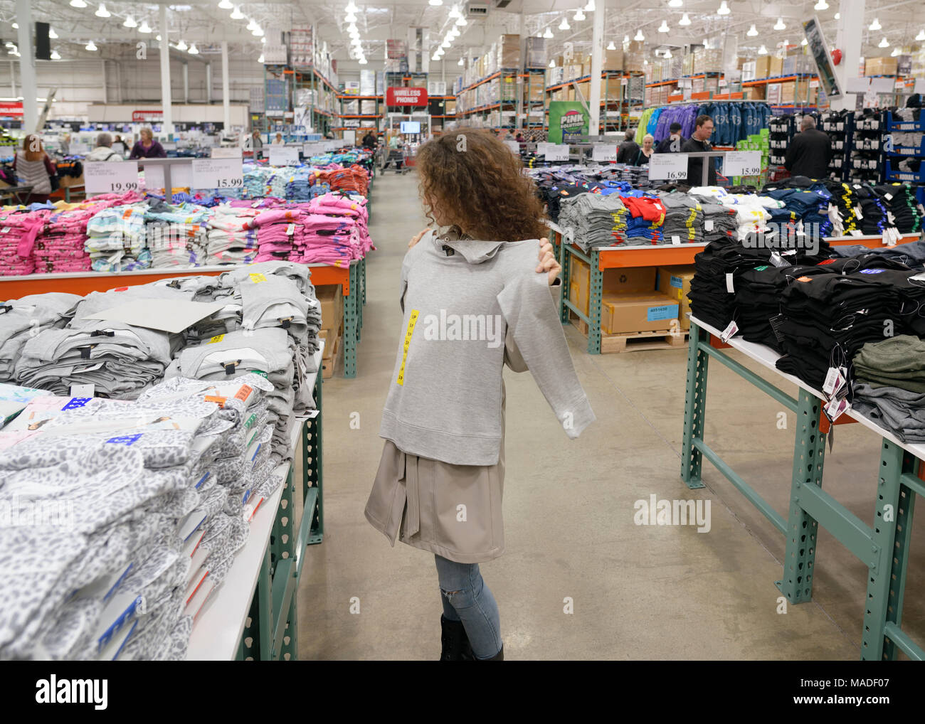 Femme essayant sur un chandail à Costco Wholesale Membership magasin-entrepôt section pour femmes. Colombie-britannique, Canada 2017. Banque D'Images