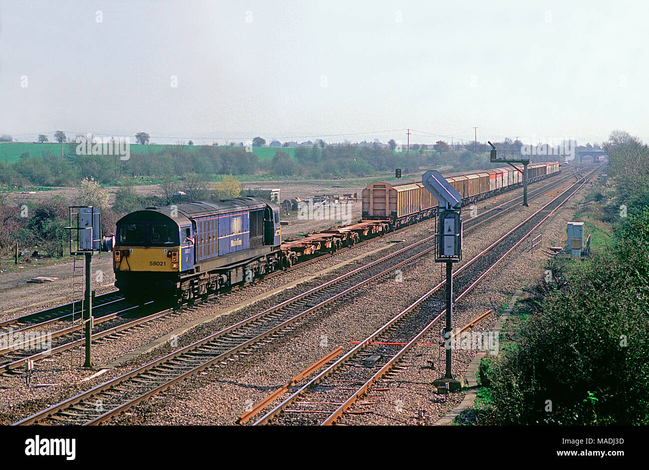 Un certain nombre de locomotives diesel de la classe 58 58021 un long travail magasins MOD locomotive arrive un contrôle de signal à South Moreton le 28 mars 2002. Banque D'Images