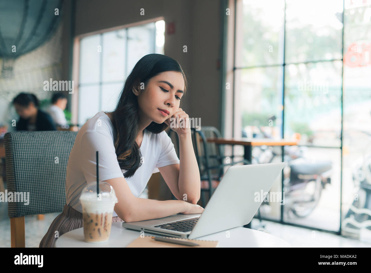 Malheureusement femme looking at laptop in a cafe Banque D'Images