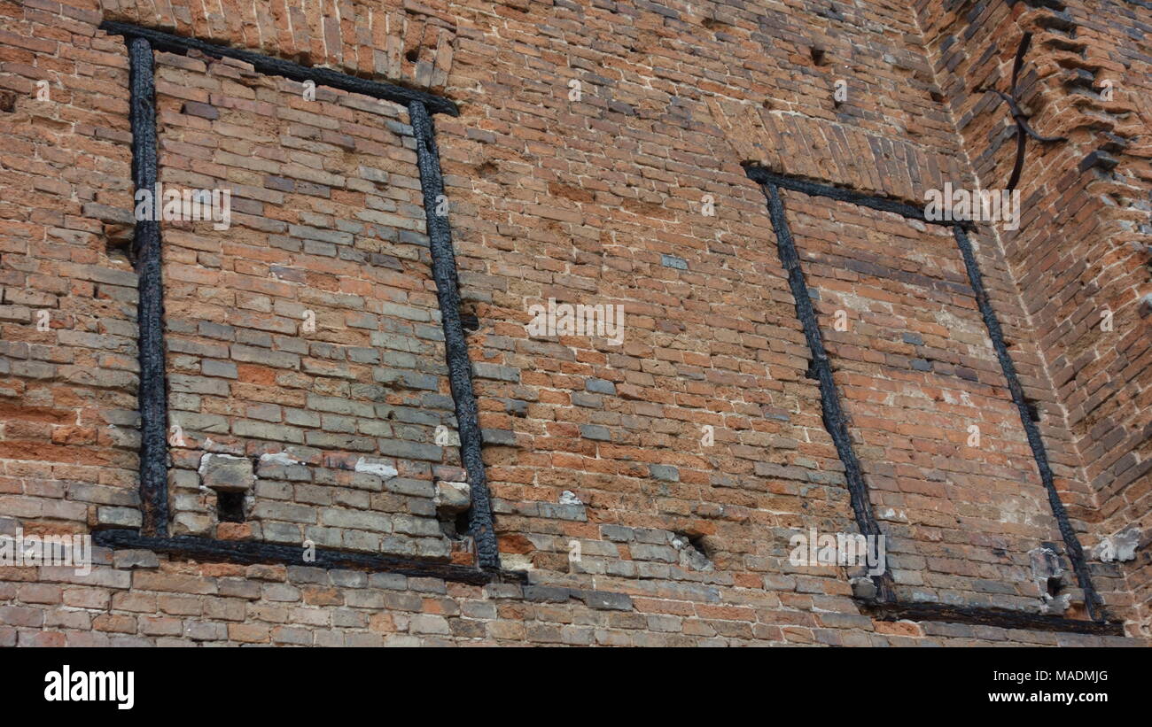 Mur de brique délabrés avec deux cadres de fenêtre grillée Banque D'Images