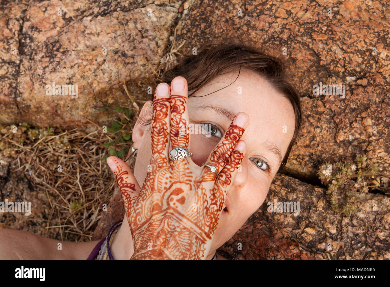 Girl taking pose selfies sur le sol avec son tatouage au henné Banque D'Images
