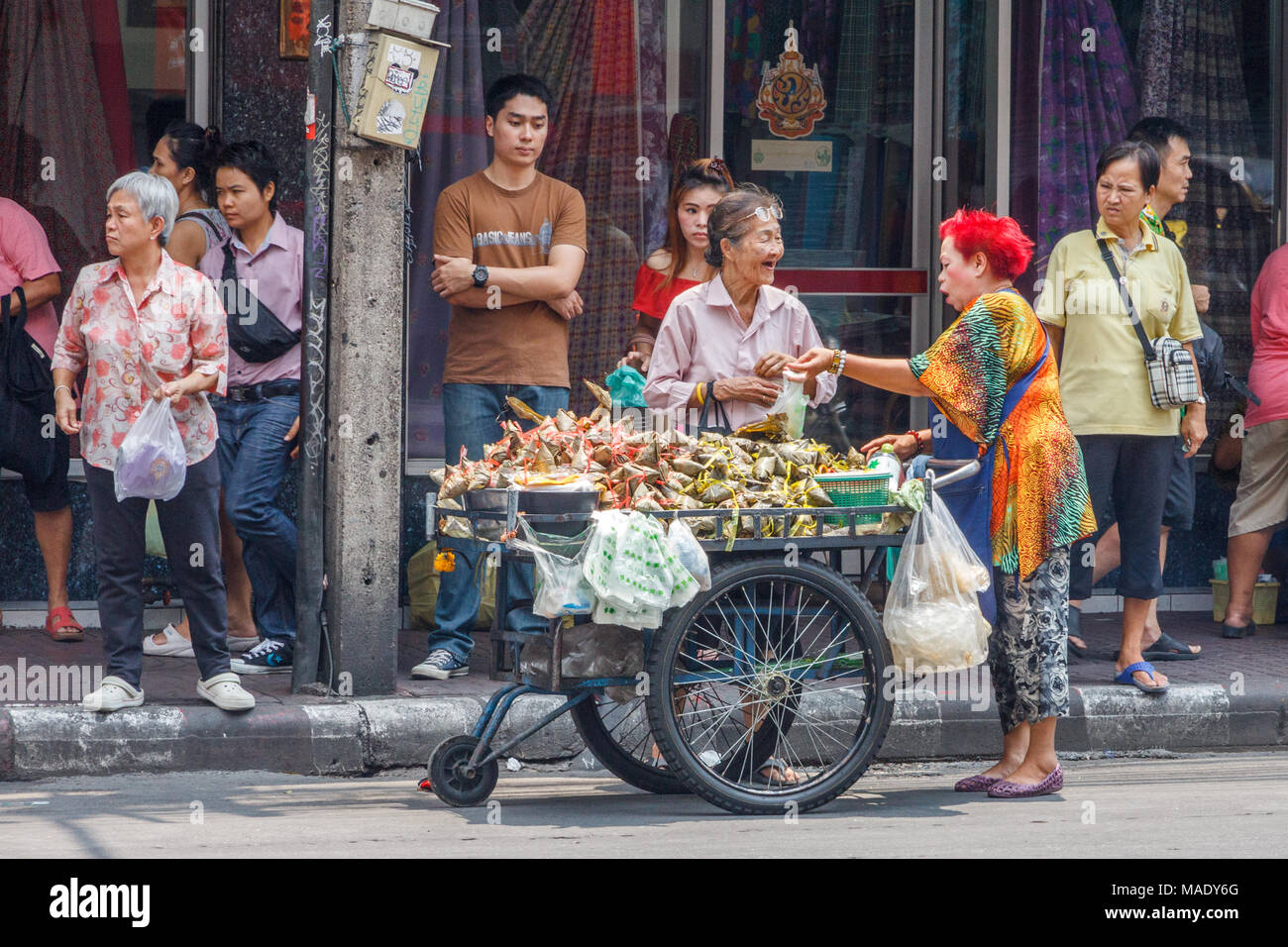 Femme acheter le riz collant à un vendeur de rue, Chinatown, Bangkok, Thaïlande Banque D'Images