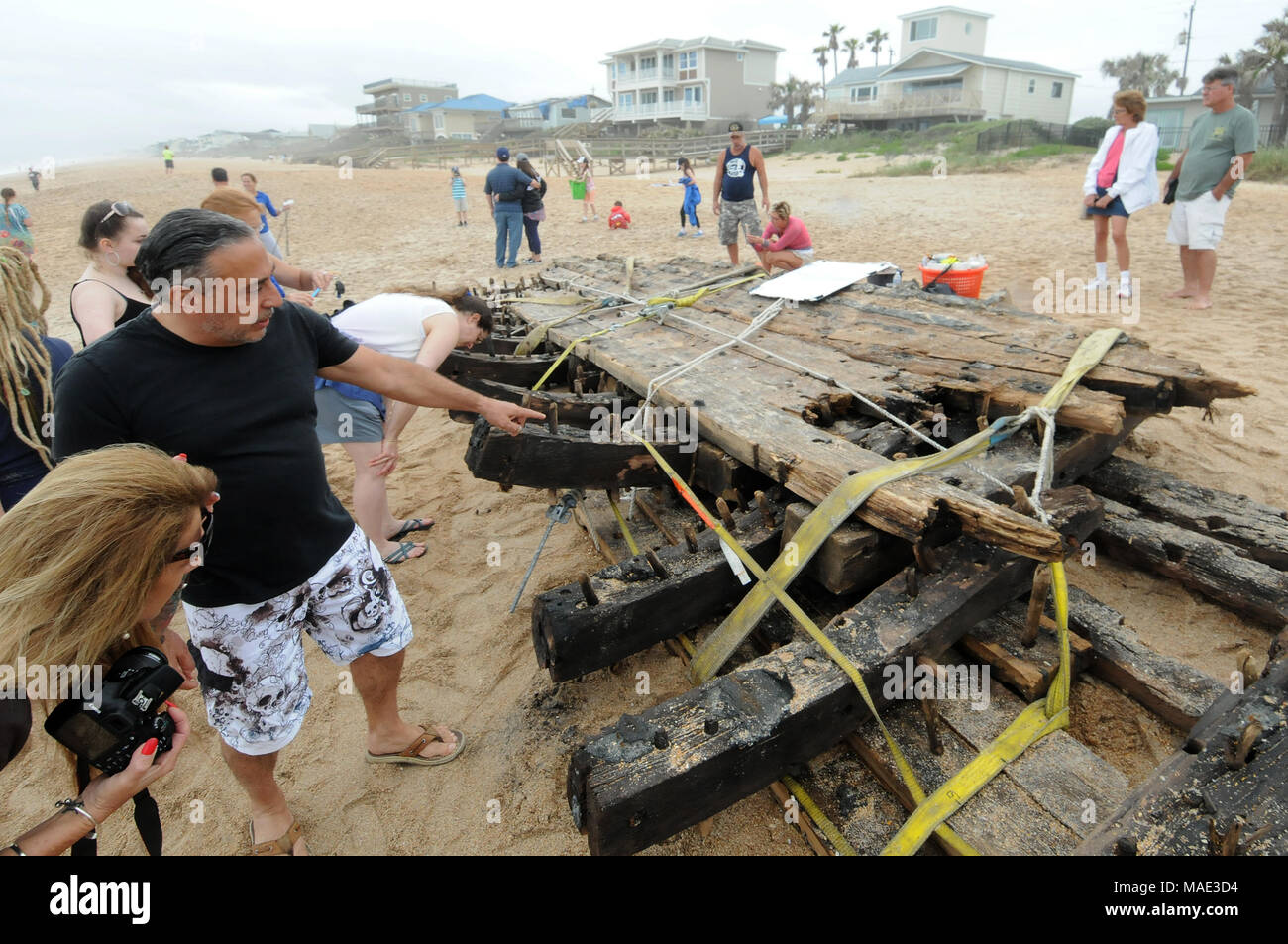 30 mars 2018 - Ponte Vedra Beach, Florida, United States - curieux voir une épave qui a été découvert le 28 mars 2018 après l'avoir lavé à terre sur Ponte Vedra Beach en Floride. Une équipe de l'archéologique Phare Saint Augustin Programme maritime étudie et mesure les 48 pieds de longueur reste en bois qui sont supposées provenir d'un navire marchand que le fret transportés le long de la côte atlantique des États-Unis du début au milieu des années 1800. (Paul Hennessy/Alamy) Banque D'Images