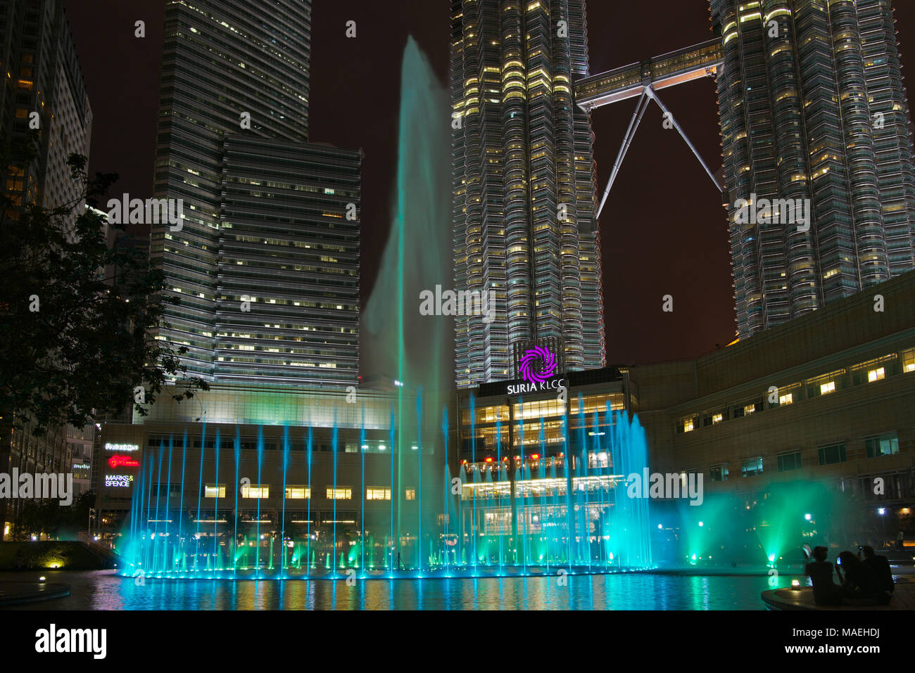 Fontaines colorées et gratte-ciel Les Tours Petronas à Kuala Lumpur, en Malaisie, de nuit Banque D'Images