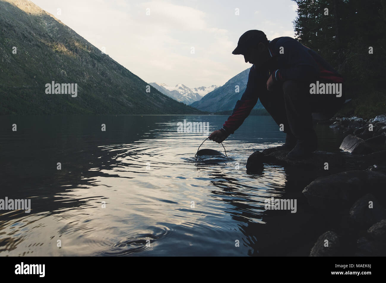 Les touristes de prendre l'eau des grands lacs d'eau douce dans le pot pour la cuisson Banque D'Images