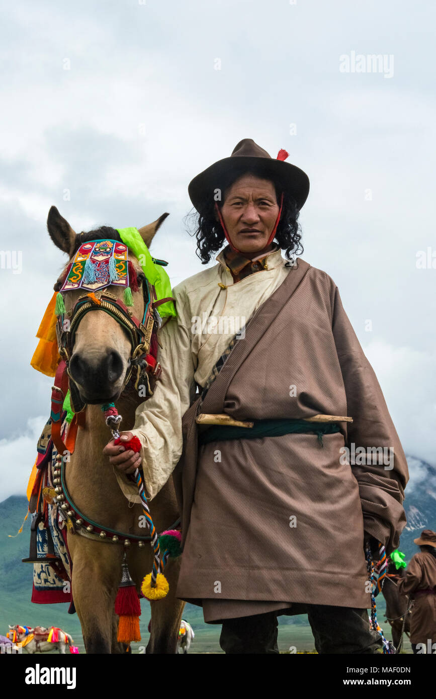 Homme tibétain à cheval en vêtements traditionnels à Horse Race Festival, Litang, l'ouest du Sichuan, Chine Banque D'Images