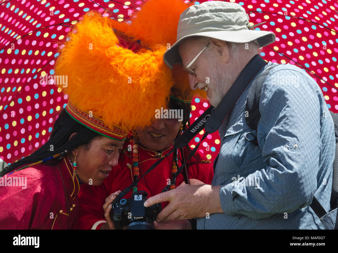 Touristiques de l'Ouest montrant un appareil photo numérique pour femme en costume traditionnel tibétain à Horse Race Festival, Litang, l'ouest du Sichuan, Chine Banque D'Images