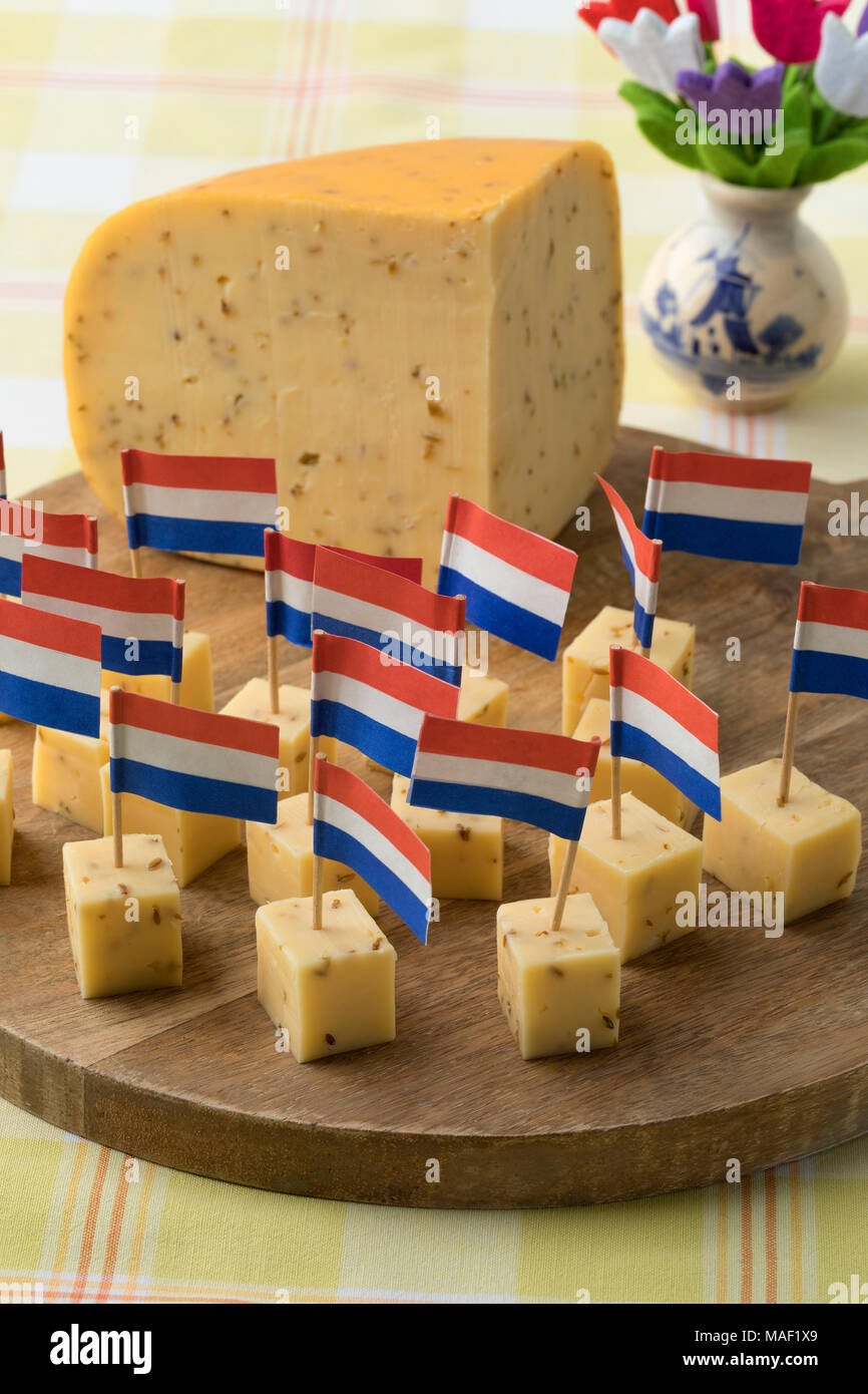 Morceaux de fromage au cumin hollandais traditionnel avec une croix rouge, blanc et bleu drapeau comme un en-cas Banque D'Images