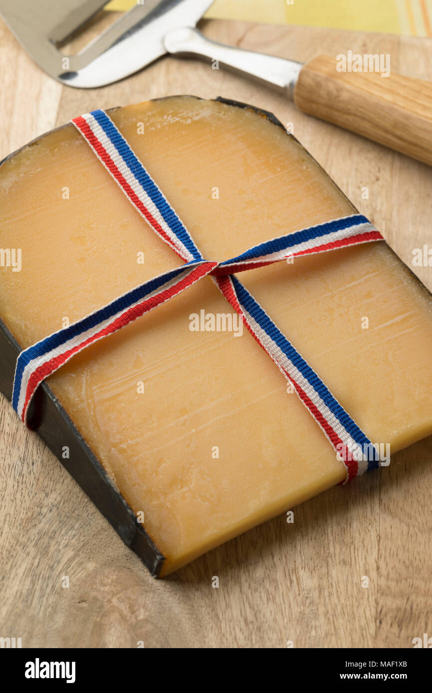 Morceau de maturité traditionnel vieux fromage Gouda Hollandais avec un red, white and blue ribbon Banque D'Images
