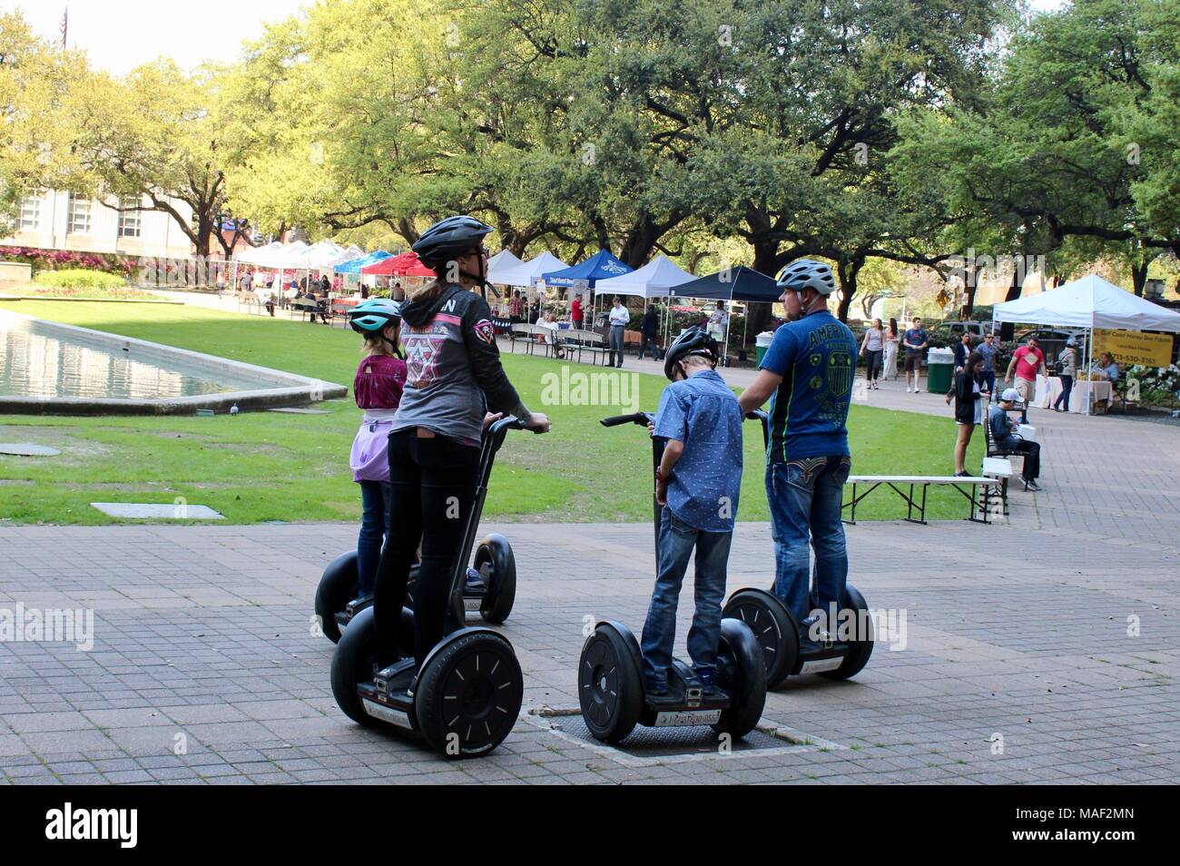 Un groupe familial sur l'utilisation d'un Segway dans un parc de Houston Texas USA Banque D'Images
